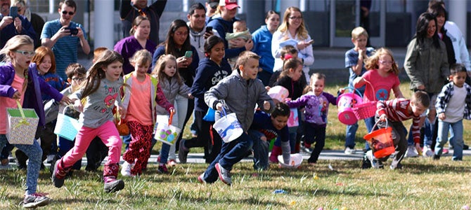 A group of kids running to collect Easter eggs at Nu Skin’s annual East Egg Hunt